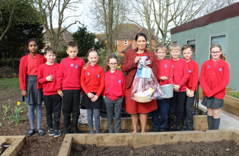 Pupils at St Andrew’s Jnr School, with Priti Patel MP in the School garden on Get Witham Growing day.